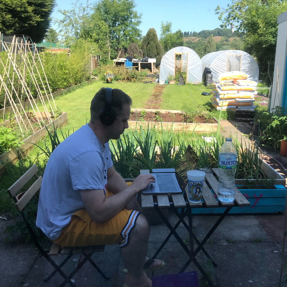 Andy working in his garden with two polytunnels